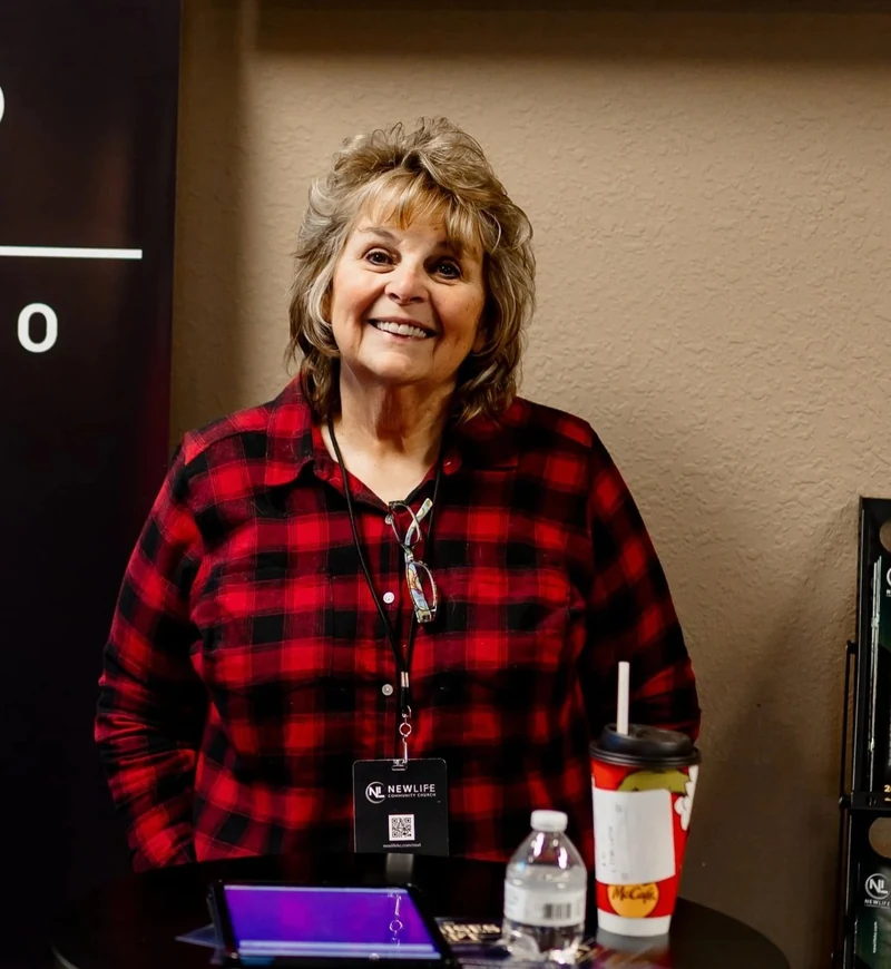 A smiling New Life welcome volunteer at the church’s welcome desk.